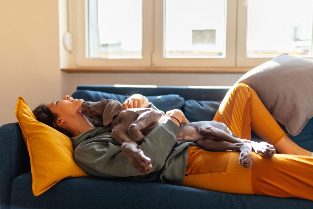 A woman's dog licking her